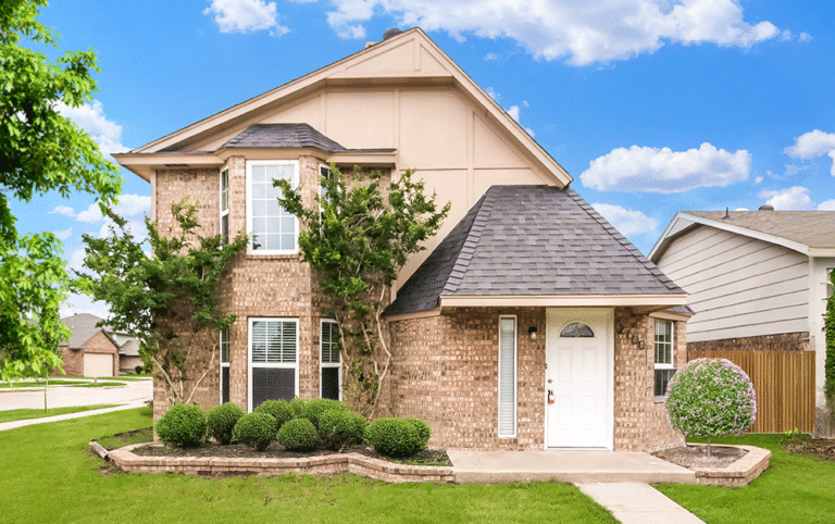 Two‑story brick home in HOA community with manicured landscaping on a sunny day.