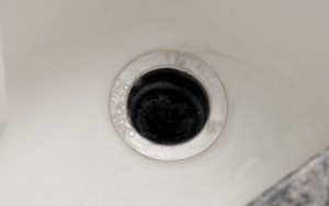 Sink drain with a garbage disposal opening seen from above.