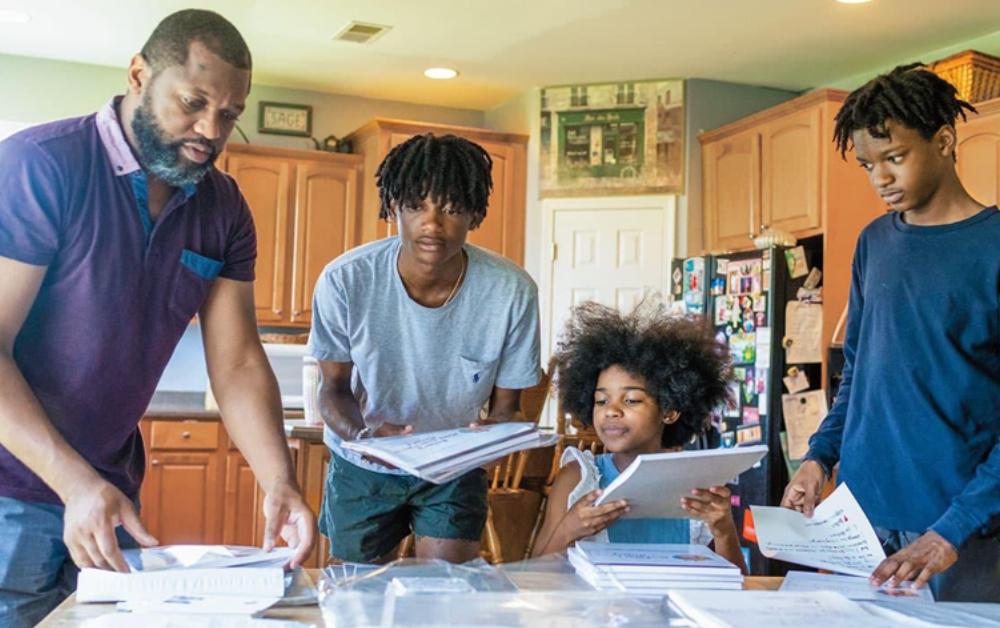 A family organizing their emergency binder with labeled tabs for documents, contacts, and insurance - recommended by Progress Residential.